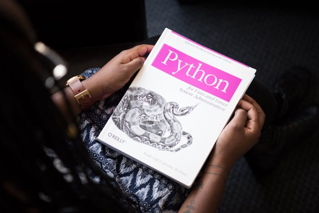 The Art of Drawing Readers In: Your attractive post title goes here A person reads 'Python for Unix and Linux System Administration' indoors.